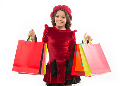 你沉溺于购物的迹象。可爱的孩子小女孩拿着一堆购物袋。孩子满意由购物查出的白色背景。痴迷于购物和服装商场。购物狂的概念