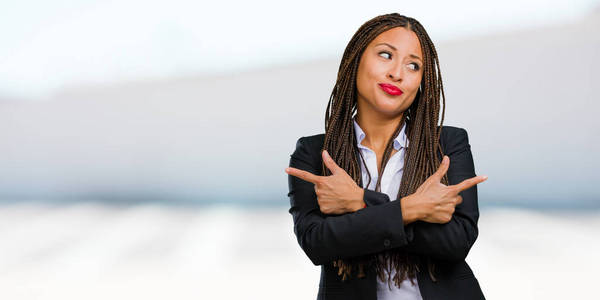 一个年轻的黑人企业妇女的肖像困惑和可疑的人, 决定在两个选项, 犹豫不决的概念