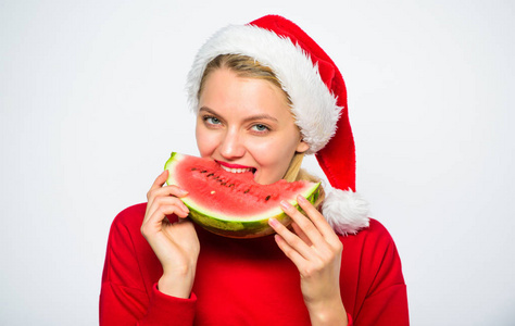 女孩圣诞老人帽子吃西瓜白色背景.享受热带圣诞节的乐趣.
