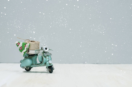 老式玩具摩托车与圣诞节礼物和树在灰色背景