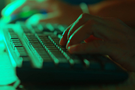 男人的手，用键盘工作。图像的颜色绿色色调