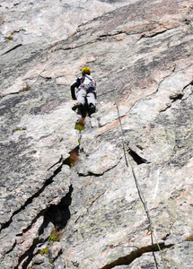 在美丽的一天, 在瑞士阿尔卑斯山陡峭的花岗岩路线登山指导攀岩者
