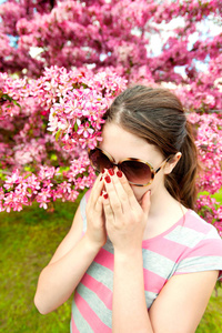 年轻十几岁的女孩有过敏嗅到的樱桃树的花朵