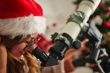 圣诞新年的喜悦与天文望远镜和可爱的女孩