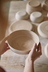 陶艺工作室藏品陶瓷碟的女性选择焦点