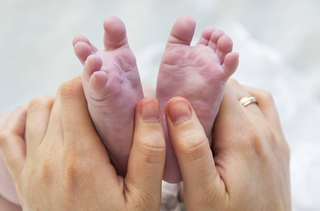 宝宝脚在母亲的手中。女性心小新生婴儿脚形手特写