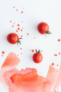 红色水彩笔触和印迹在白色表面上成熟樱桃西红柿的顶部视图