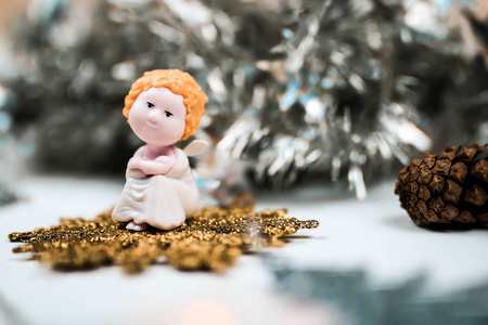 可爱的玩具天使与长笛和冷杉锥体垂悬和装饰一棵圣诞树