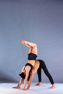 年轻夫妇一起练习杂技瑜伽工作室在垫子上