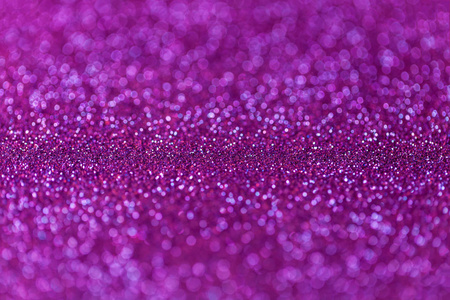 从小的亮片，特写的紫色波光粼粼背景。辉煌的背景