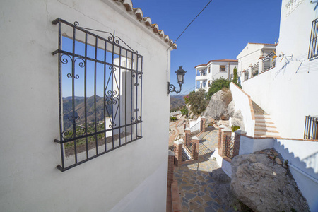 山脉景观通过开放的窗口在科马雷斯白色村庄, 马拉加山脉, 安达卢西亚, 西班牙