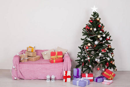 白色房间里的圣诞树, 有圣诞装饰品和礼物玩具