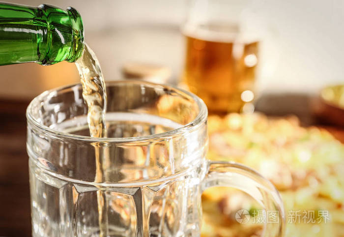 把啤酒倒在比萨背景上照片-正版商用图片0tdwrc-摄图新视界