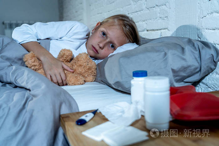 甜言蜜语生病可爱的女孩感觉生病躺在床上与药物温度计热水袋患有冷和