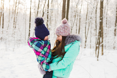 快乐家庭母亲和婴儿女孩女儿玩耍和欢笑中冬季户外在雪中