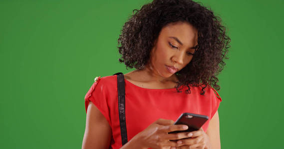 休闲现代黑人女性使用手机在绿色屏幕上的文字
