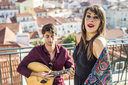 美丽的法多歌手表演与英俊的葡萄牙吉他手球员在阿尔法马, 里斯本, 葡萄牙