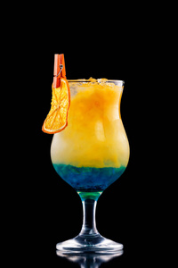 特写玻璃蓝色 curacao 鸡尾酒装饰与橙色查出在黑色背景照片