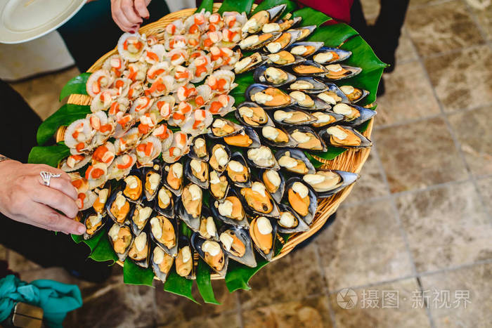 在美食聚会上提供的有香料的煮熟贻贝托盘