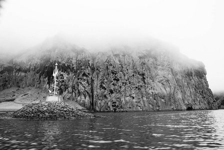 heimaey, 冰岛, 在薄雾笼罩的天空中的岩石海海岸。沿海岸线的山脉形成。海在山风景。具有良好生态和环境理念的自然