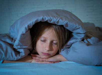 可爱的小白种人女孩躺在床上覆盖着她的头与毯子感到疲惫和不眠不休的痛苦失眠抑郁症压力在儿童情绪和睡眠障碍的概念