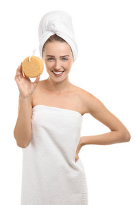 美丽的年轻女子包裹在毛巾举行淋浴海绵在白色背景