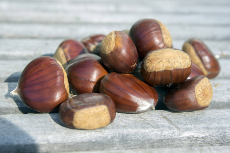 散落坚果原始甜栗子散落在木桌上, 美味健康的棕色坚果照片