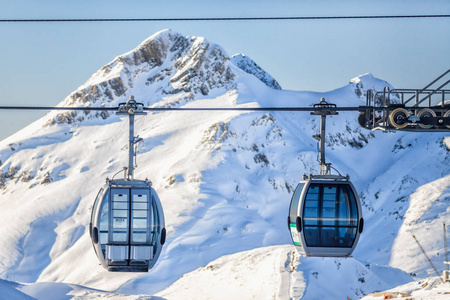 两个索道滑雪缆车车厢上雪山背景