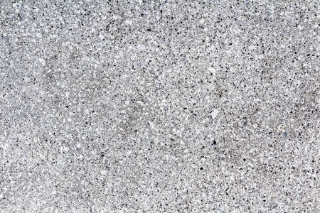 纹理灰色花岗岩。光滑的浅色石材纹理。灰色。许多带有深色内含物的小石头
