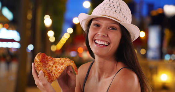 晚上香榭丽舍大街上的年轻旅游妇女在享受比萨饼