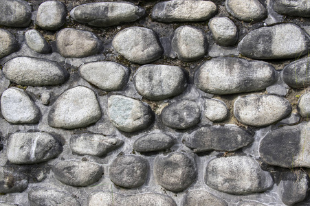由河石石头背景墙壁路面灰色和棕色深色制成的墙的细节