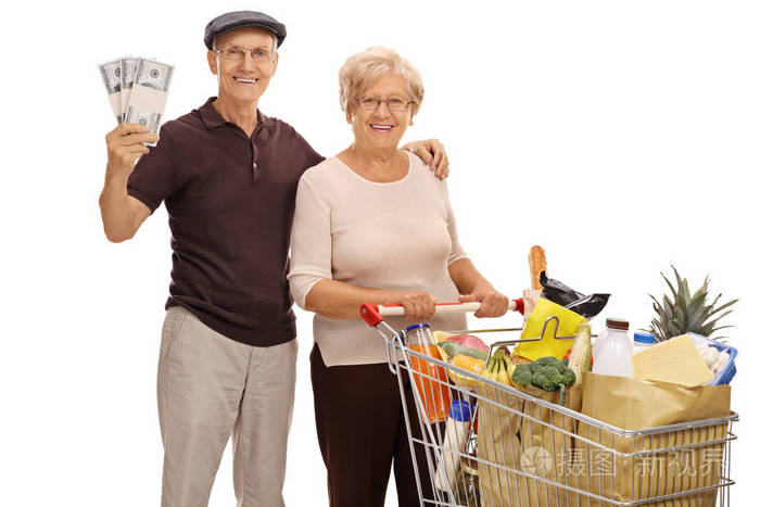 老年人与钱束和购物车装满了食品杂货