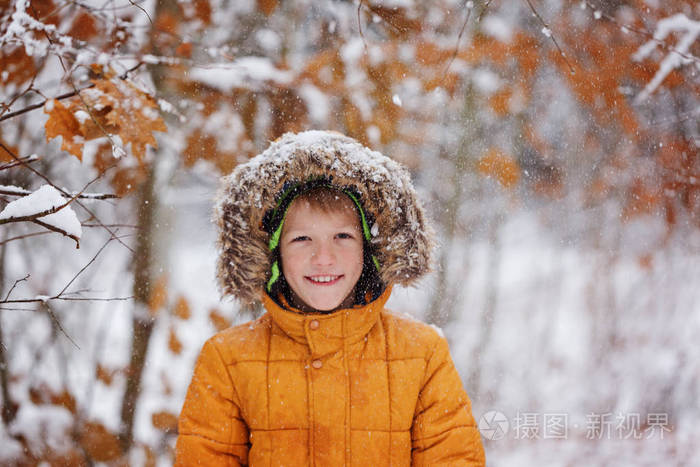 可爱的小男孩,在冬天的衣服走在雪下的孩子