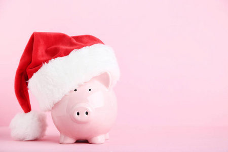 粉红色的猪圈与圣诞老人帽子在粉红色的背景
