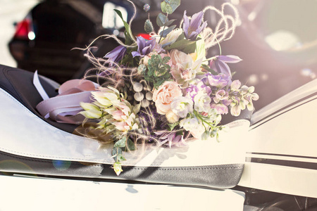 美丽的花束与精致的花朵。粉红白色紫色花束。女性手中的新娘花束