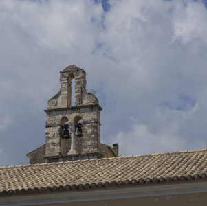 传统的希腊教会石钟塔和屋顶在科孚镇, 科孚希腊, 蓝天白云