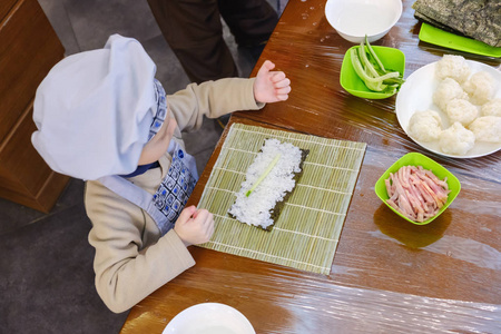 烹调, 准备传统寿司卷。这个男孩打扮得像个厨师。