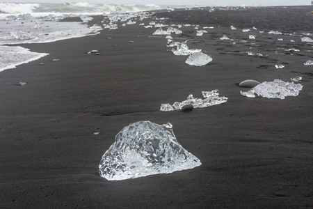 在冰岛南部的钻石海滩, 那里的冰从 Jokulsarlon Glaciar 泻湖向大海冲回海滩, 并与黑沙。
