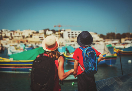 母亲和儿子看着传统的小船在马耳他