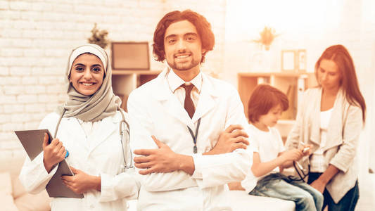 微笑的阿拉伯医生的画像儿科医生。自信的穆斯林医生站在办公室里。儿科医生的孩子。医院理念。健康的理念。儿童病人访问医生