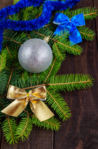 绿枝的冷杉，装饰着五彩缤纷的彩带和银球上深色木制背景。节日作文 圣诞节 新年
