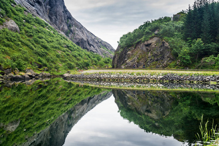 风景如画的岩石反映在挪威北德兰县洛福滕群岛的清澈水域。国家旅游路线洛福滕