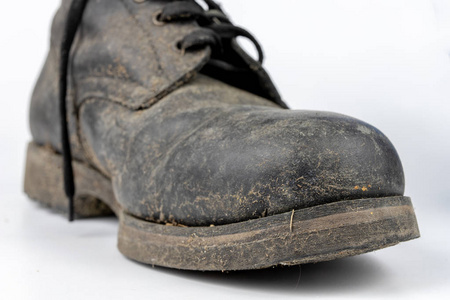 白色桌子上的皮革军鞋.浅色背景照片