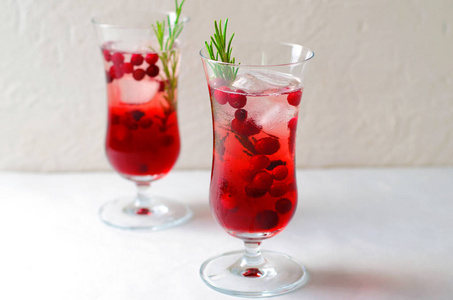 红莓鸡尾酒与冰和迷迭香在白色背景, 清爽的饮料