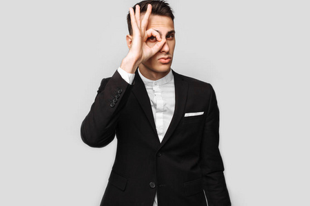 赞美小宝宝表情一个年轻英俊快乐的男人的肖像, 穿着西装, 微笑着, 在