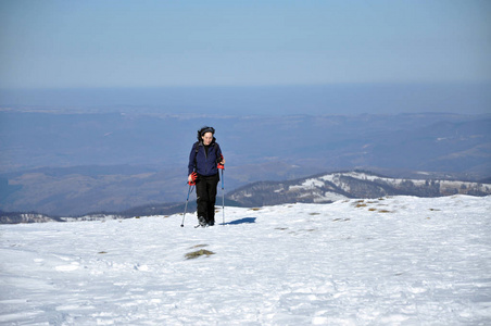 女人做冬季在山里徒步旅行