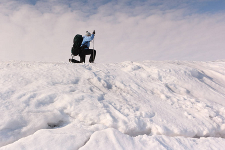 女人旅行者在雪面上滑雪，背包里