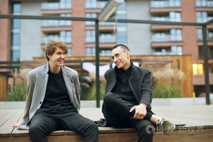 午饭时间, 两位同事坐在办公室附近.朋友们坐着, 笑着, 说话, 微笑.