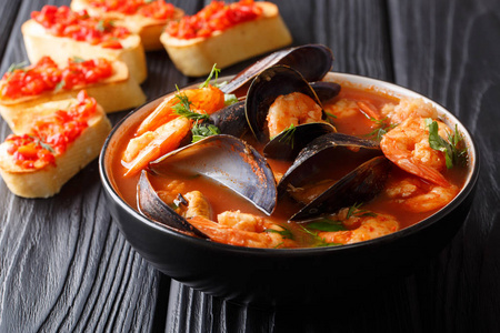 传统的法式布伊拉贝塞汤食谱, 在桌上的碗里放海鲜和鱼特写镜头。沃尔顿塔