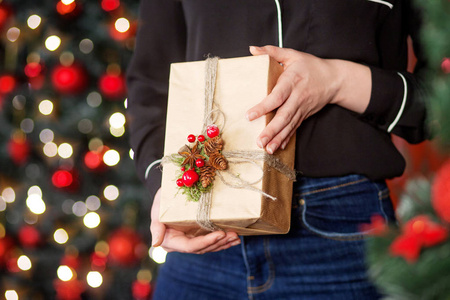 女性手拿着礼品盒。圣诞节, 新年, 生日概念。节日背景与波克和阳光。魔术童话